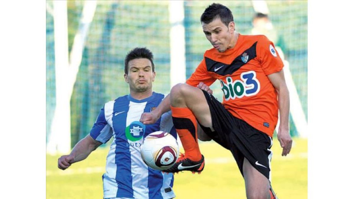 El deportivista Domenech controla el balón a media altura en una jugada en el mediocampo.
