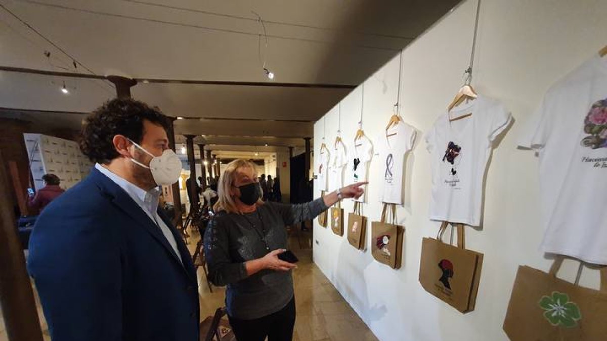 La concejala de Mujer Carmen Oláiz muestra al alcalde de Villaquilambre objetos de la exposición. DL