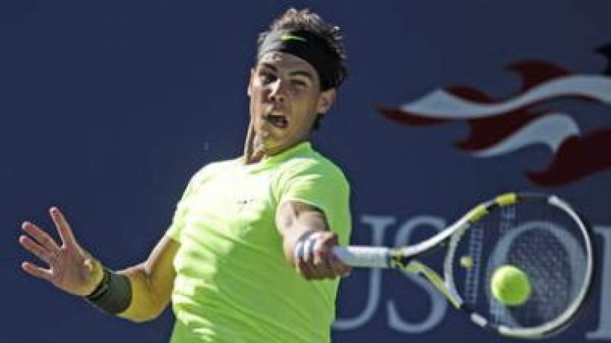 El tenista español Rafael Nadal devuelve la bola al francés Gilles Simon.