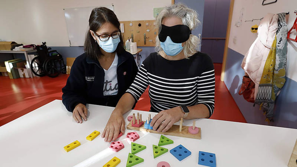 Ana María Llorente, en una de las terapias que realiza en el centro que Aspaym tiene en León, junto a Alejandra, la terapeuta. MARCIANO PÉREZ