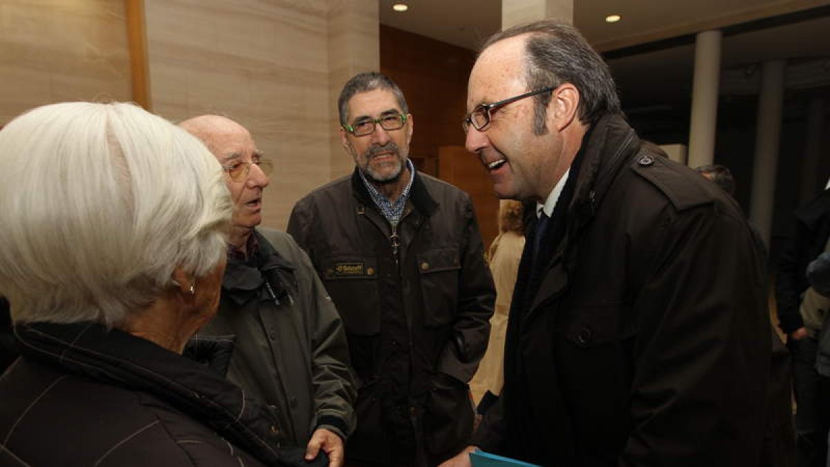 César Gavela (derecha) departe con un grupo de asistentes al acto en la Obra Social.