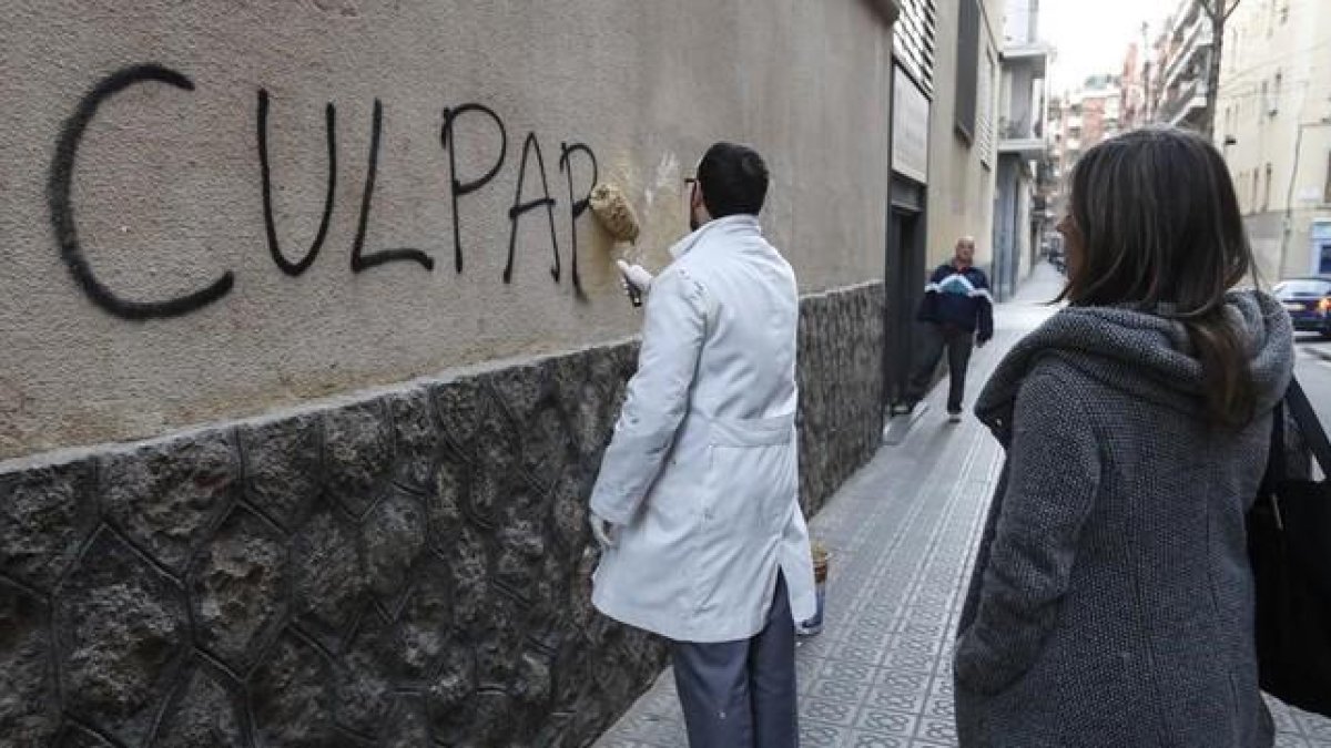 Un trabajador borra una pintada en el muro del colegio de los Maristas de Sants-Les Corts, tras estallar el escándalo de pederastia en el centro.