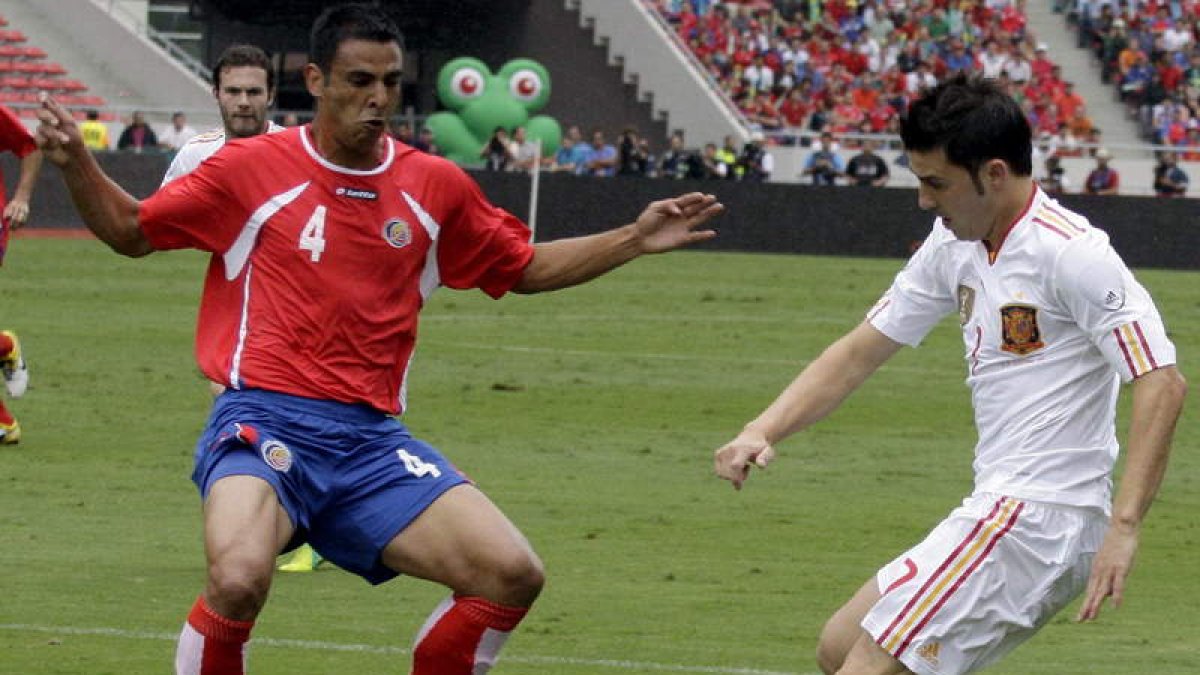 El jugador de la selección española David Villa disputa el balón con Michael Umaña.