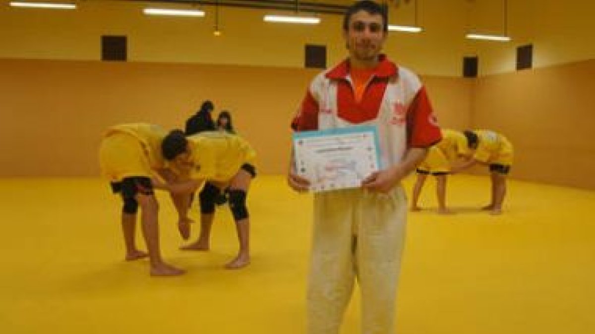 El campeón de España de Sambo, Ángel Carrizo, con su título en la sala de entrenamiento.