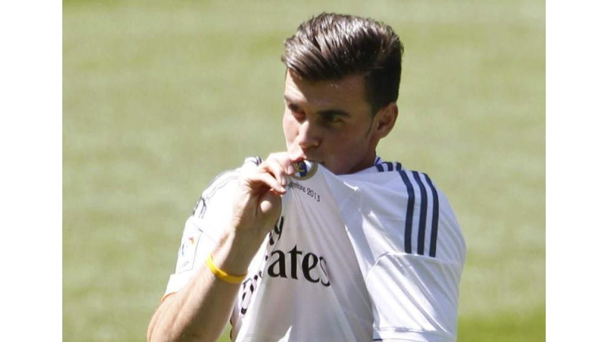 El jugador galés Gareth Bale besa el escudo del Real Madrid durante su presentación.