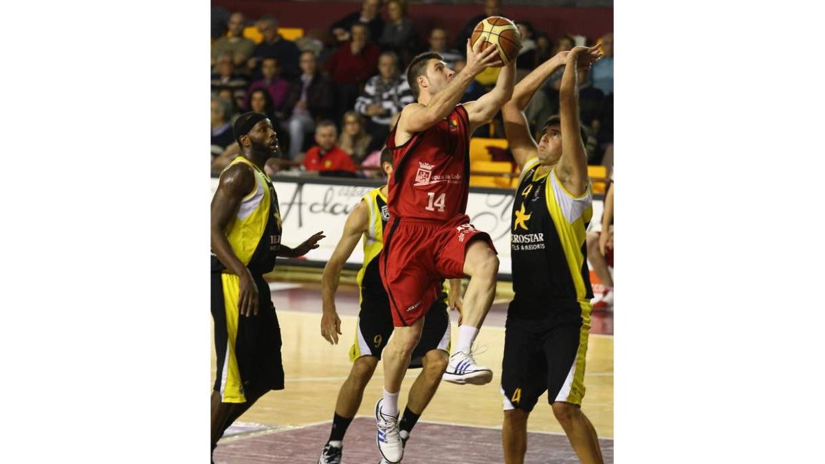 Julio ejecuta una acción ofensiva de Baloncesto León ante la oposición de Guillén y Donaldson.