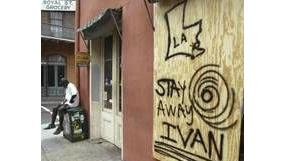 Un hombre lee el periódico al lado de un tablón que advierte a «Iván» que se mantenga alejado
