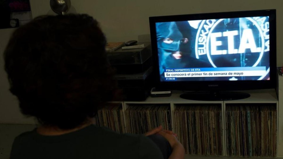 Una mujer mira en televisión la noticia sobrela disolución de ETA, este miércoles. /