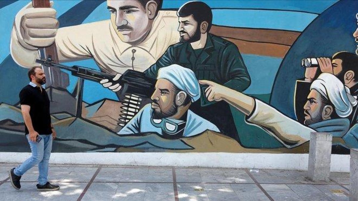 Un hombre camina delante de un mural en Teherán (Irán).