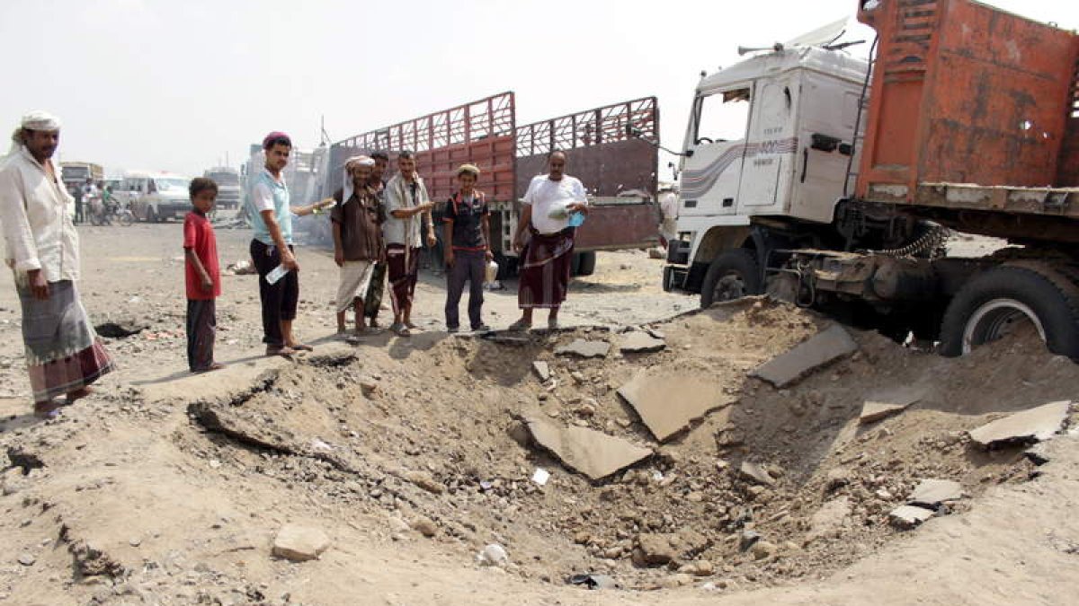 Varios yemeníes contemplan los destrozos provocados por un bombardeo aéreo.