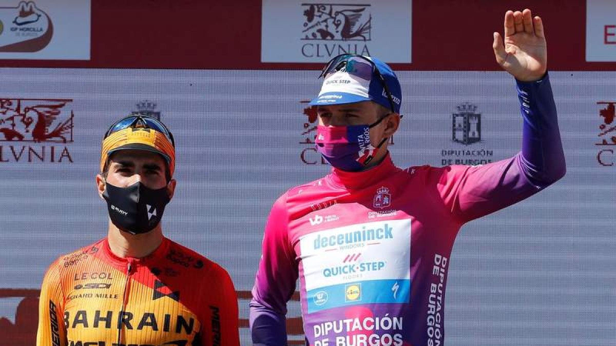 Remco Evenepoel escoltado en el podio por Mikel Landa. SANTI OTERO
