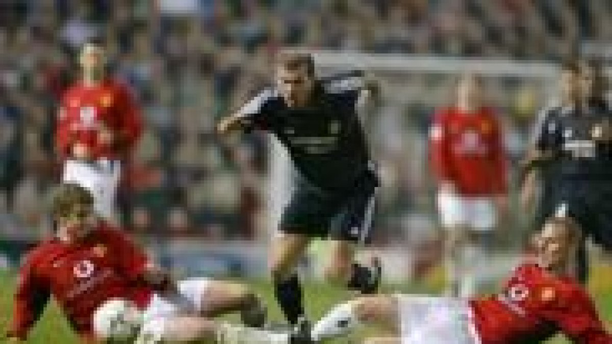 Zidane avanza con el balón controlado entre Solskjaer y Butt