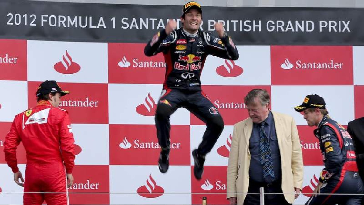El australiano Mark Webber, de Red Bull, celebra en el podio con un gran salto su victoria en el Gran Premio de Gran Bretaña ante Alonso y su compañero Vettel.