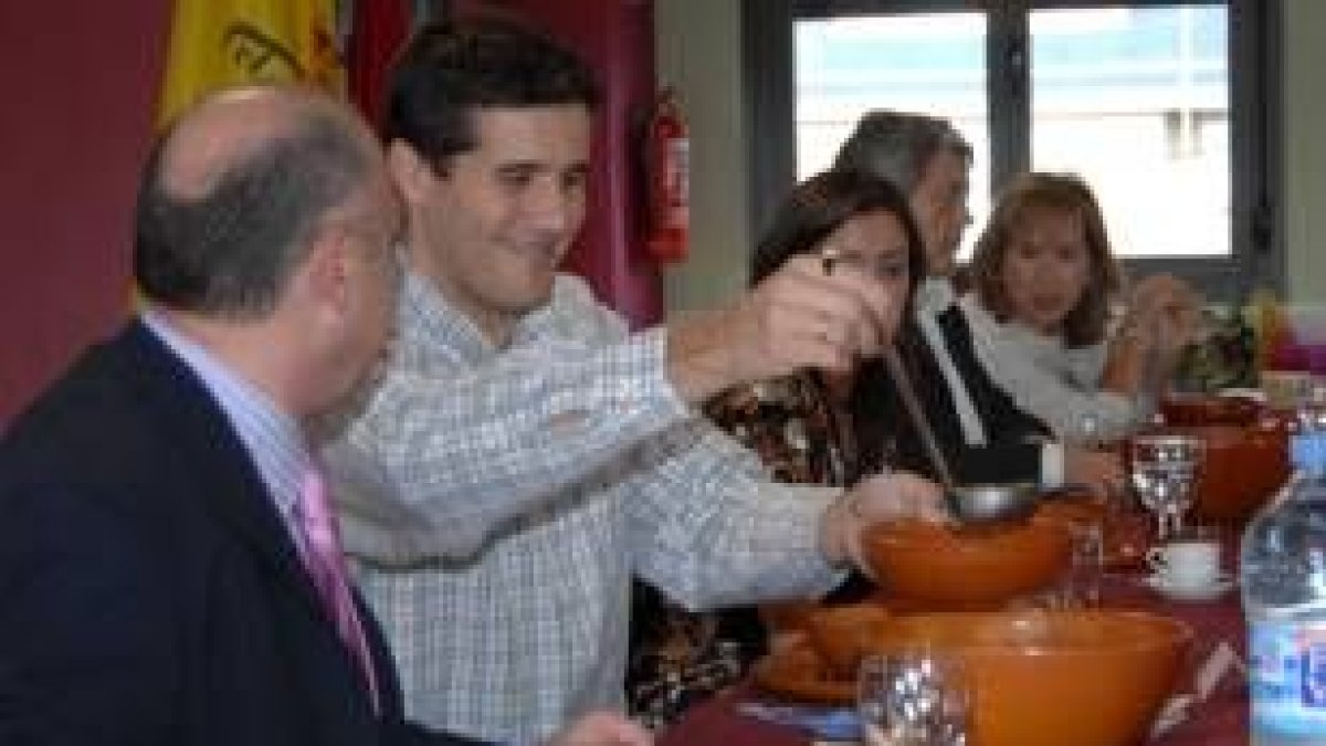 Castresana se sirve la sopa del cocido, mientras conversa con el presidente de la Casa León