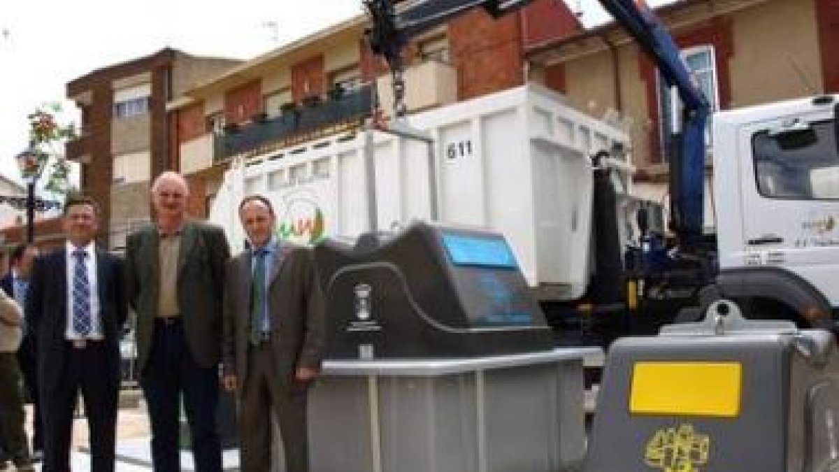 El presidente de la mancomunidad, en el centro, posa junto a los nuevos contenedores.