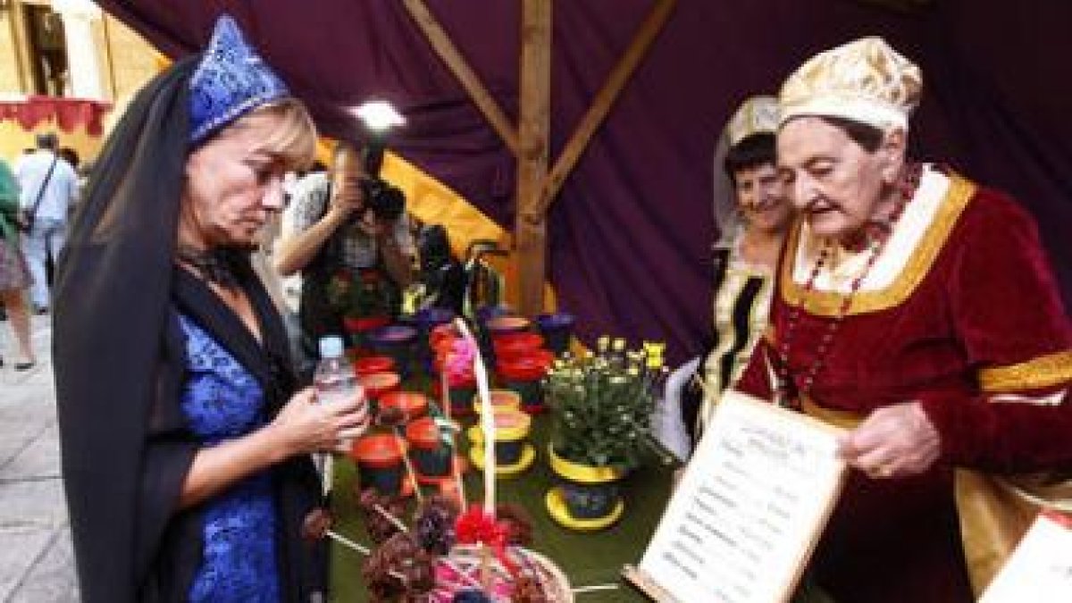 Isabel Carrasco se interesa por los productos expuestos en los stands de los centros.