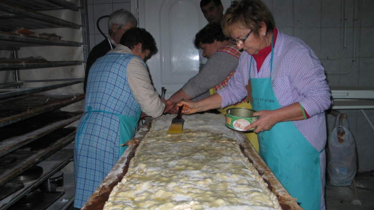Vecinos de Villaverde de la Abadía elaborando una de las empanadas de tres metros.