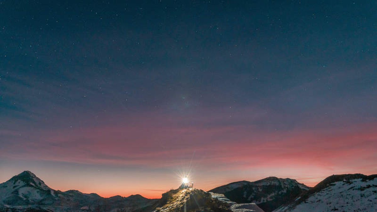 Siara y su perro Casimiro en la cima de Las Roscas, en el alto nevado del Pando, deslumbrados por la luz en un atardecer de invierno leonés que se                 adivina estrellado.