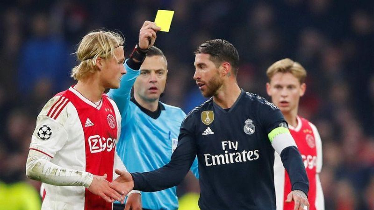 Sergio Ramos (d) recibe la amarilla durante el partido contra el Ajax.