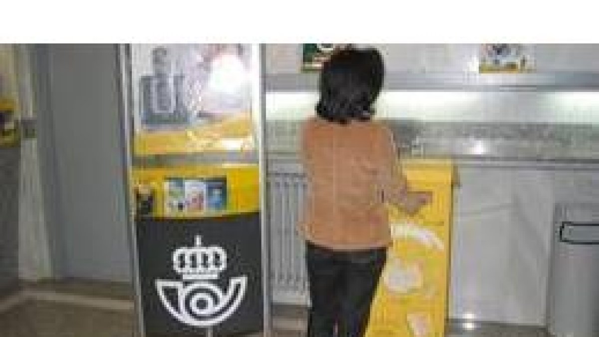 Una mujer deposita su aportación a la campaña en el buzón de la oficina de Correos