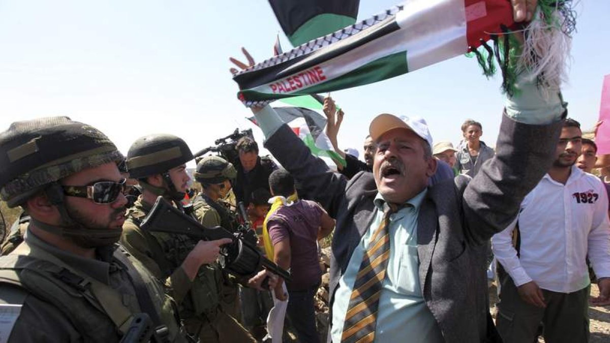 Un grupo de palestinos, rodeados por soldados israelíes, se manifiestan en Hebrón.