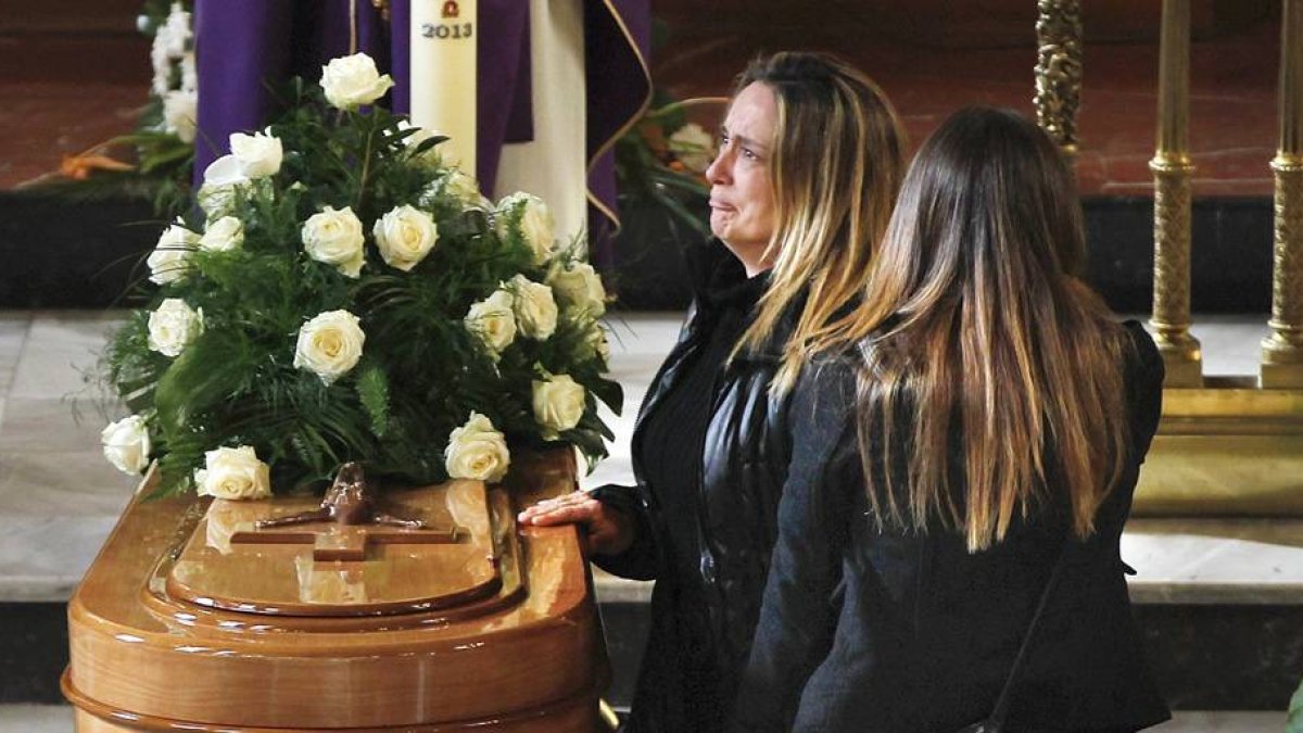 La viuda de José Luis Arias, de 45 años, el minero asturiano fallecido el pasado lunes junto a cinco compañeros leoneses en el pozo Emilio Valle de Pola de Gordón (León), junto al féretro de su esposo, durante el funeral en su memoria.