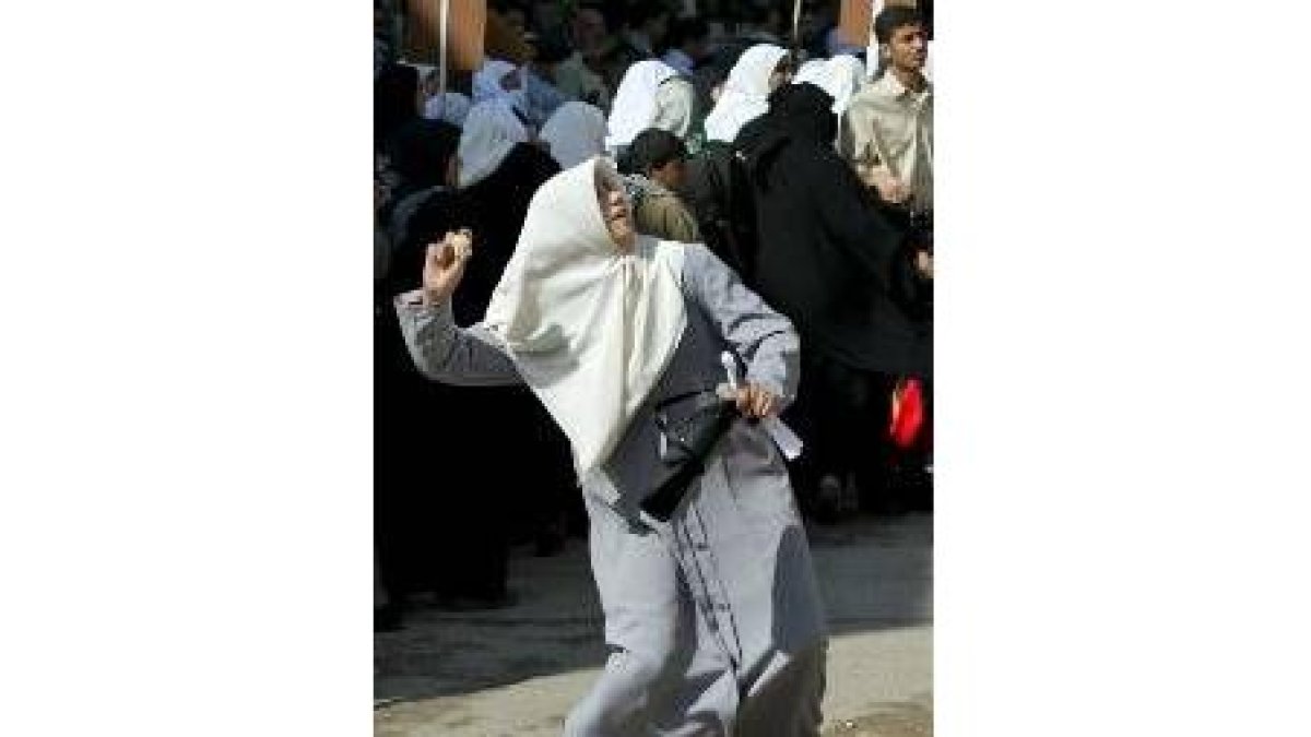 Una mujer palestina lanza una piedra durante una protesta en Gaza