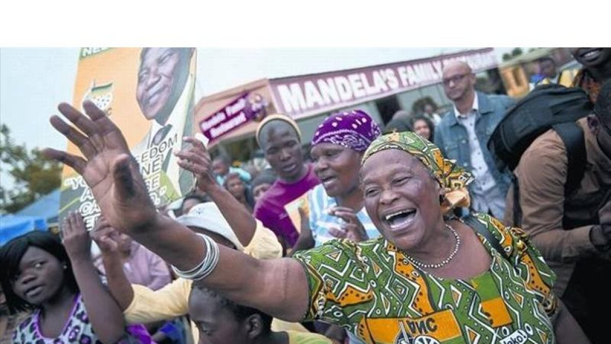 Ciudadanos sudafricanos lloran, danzan y cantan para rendir homenaje al líder fallecido, delante del antiguo hogar de Mandela, en Soweto, ayer.