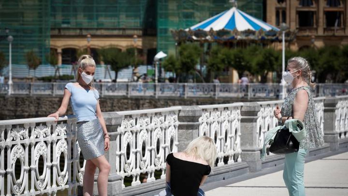 Los primeros turistas se han dejado ver este jueves fotografiándose junto a la playa de La Concha de San Sebastián. JAVIER ETXEZARRETA