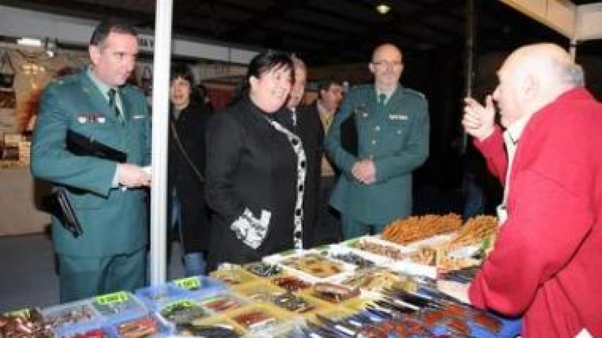 Ana Luisa Durán conversa con uno de los participantes en la feria en presencia de los mandos de la G