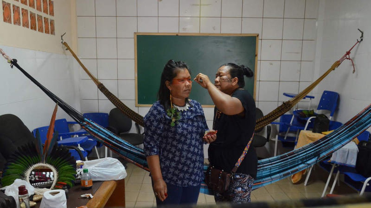 Edna Shanenawa pinta la cara de su hermana Ismail Shanenawa antes de la partida. ODAIR LEAL