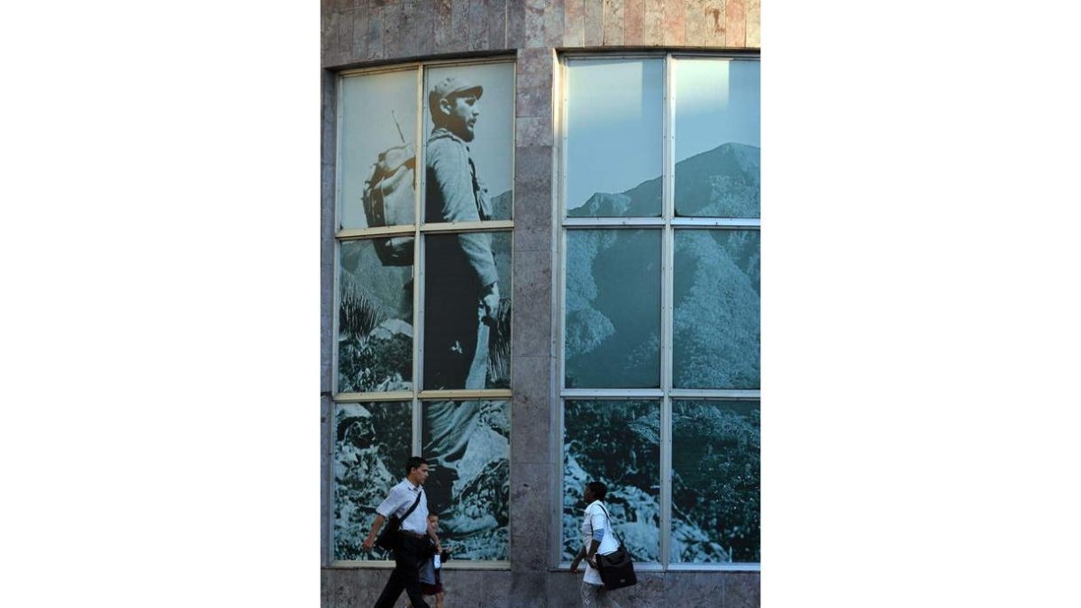 Varias personas, junto a una imagen de Fidel Castro.