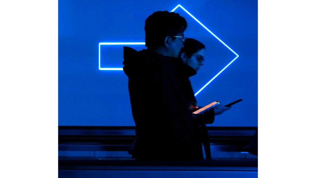 Jóvenes consultan el teléfono móvil. efe