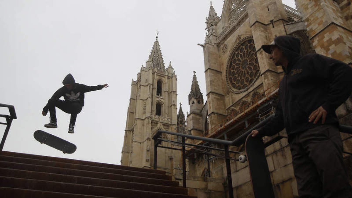Los trucos sobre el monopatín de Pablo en las escaleras de la Catedral de León los sigue su compañero Óscar con la máxima atención. El skate es su vida.