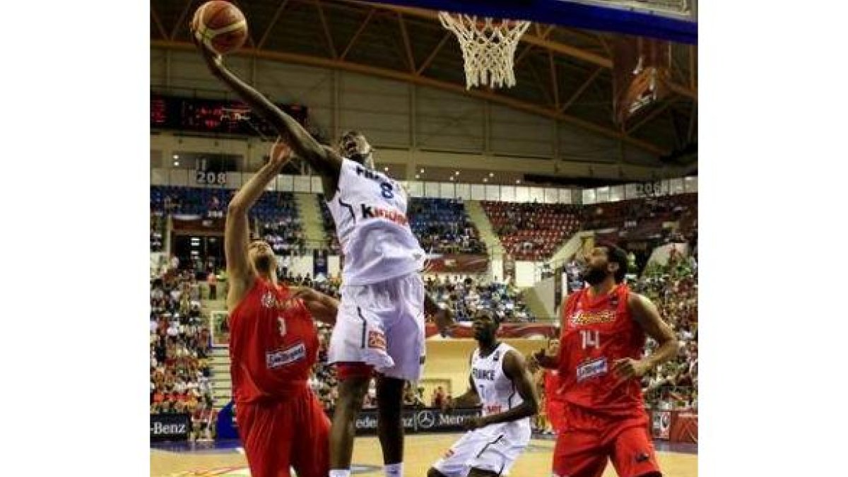 Raúl y Mumbrú intentan capturar un rebote ante el francés de los Mavericks Ian Mahinmi.