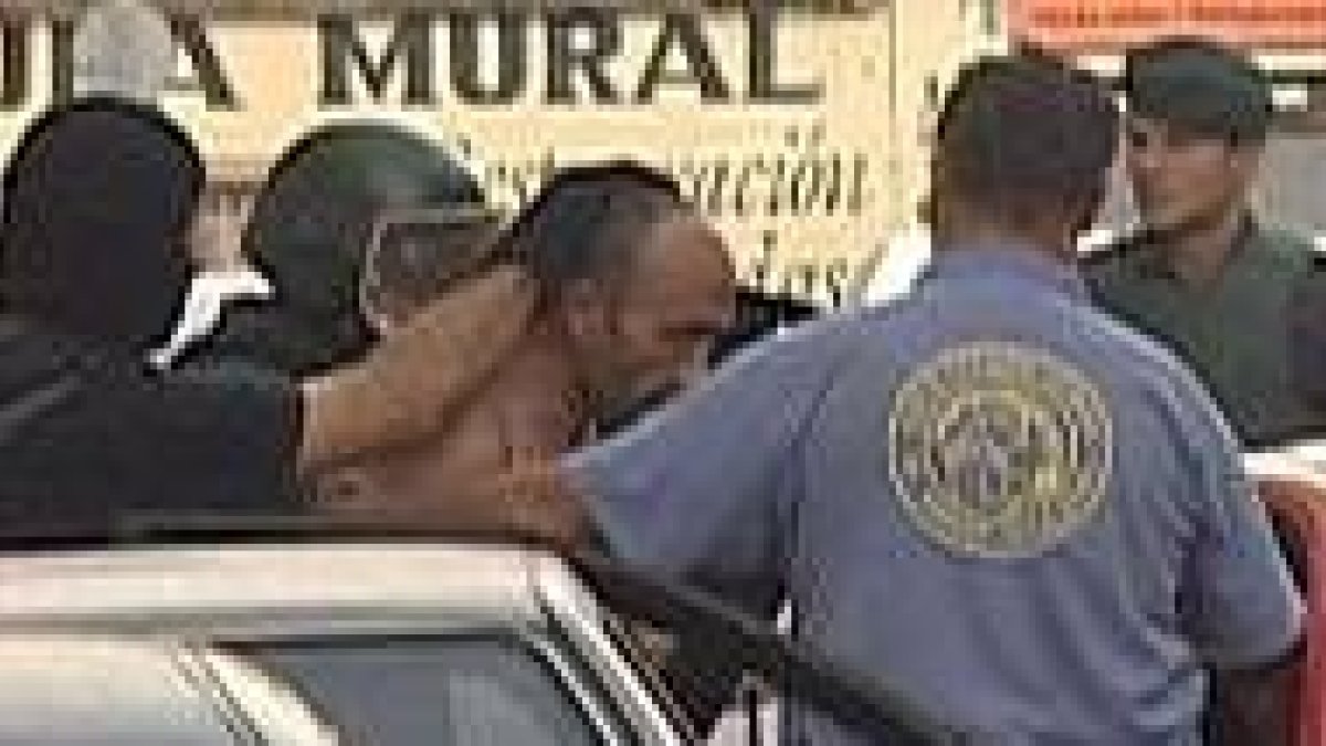 La policía introduce en un coche al presunto homicida