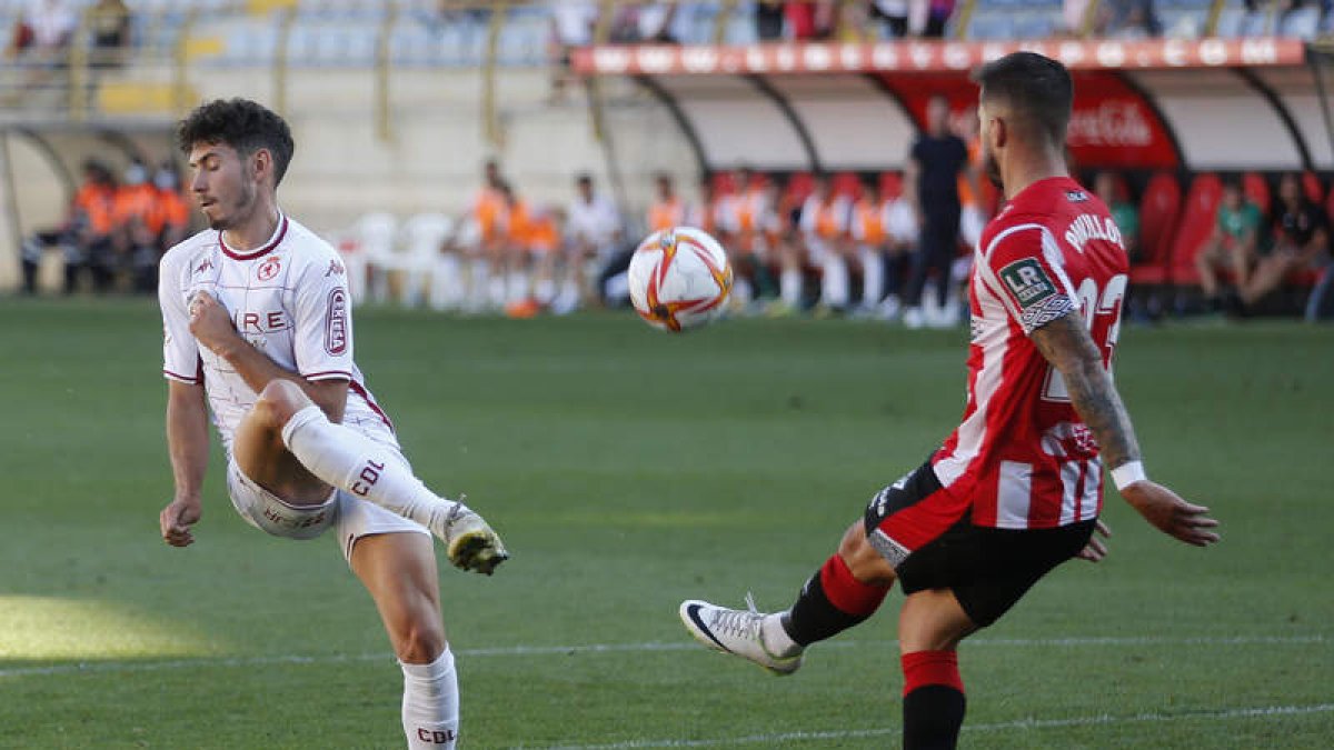 Aarón Piñán trata de interceptar el despeje del jugador riojano David Ramos tras un balón colgado desde el centro del campo culturalista. FERNANDO OTERO