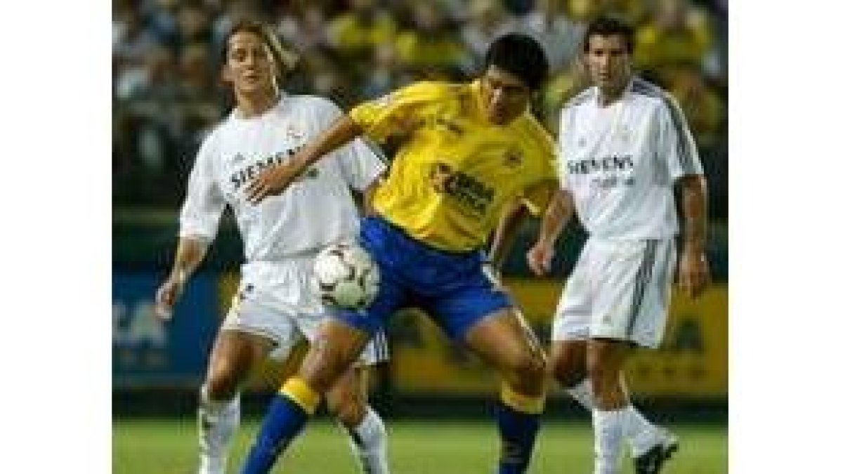 Riquelme trata de hacerse con el control de un balón por el que también pujan Michel Salgado y Figo