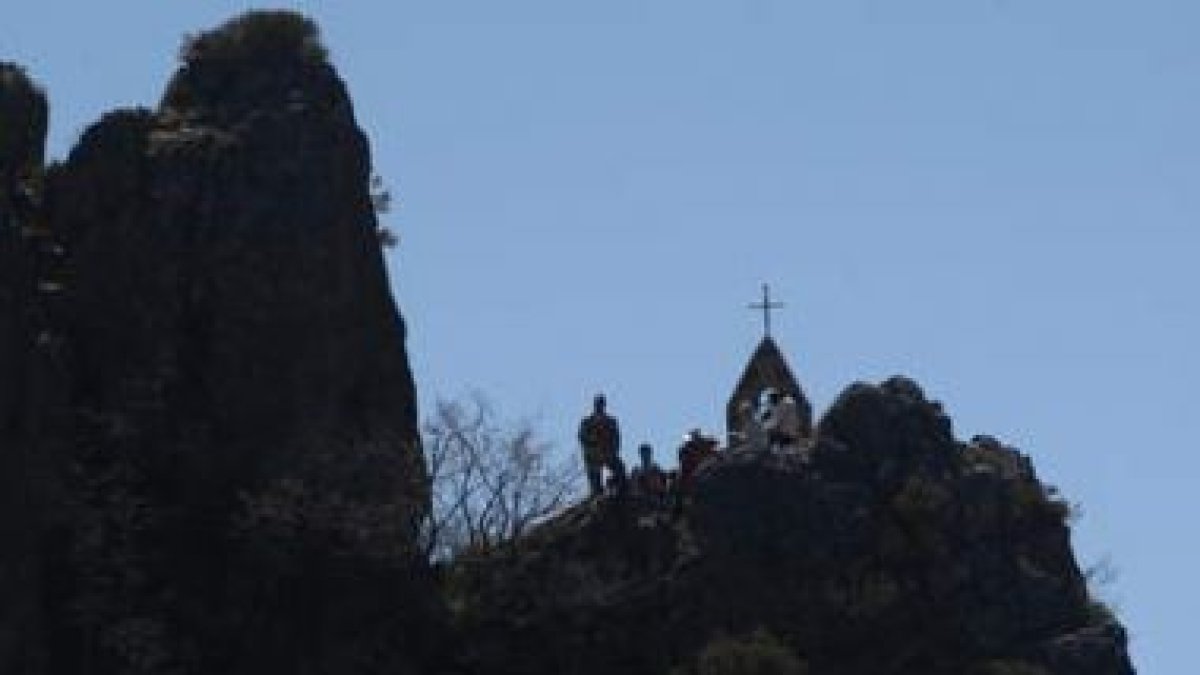 La ermita de Valdorria, arriba en la peña, y el pueblo en una peregrinación. En la foto pequeña, la