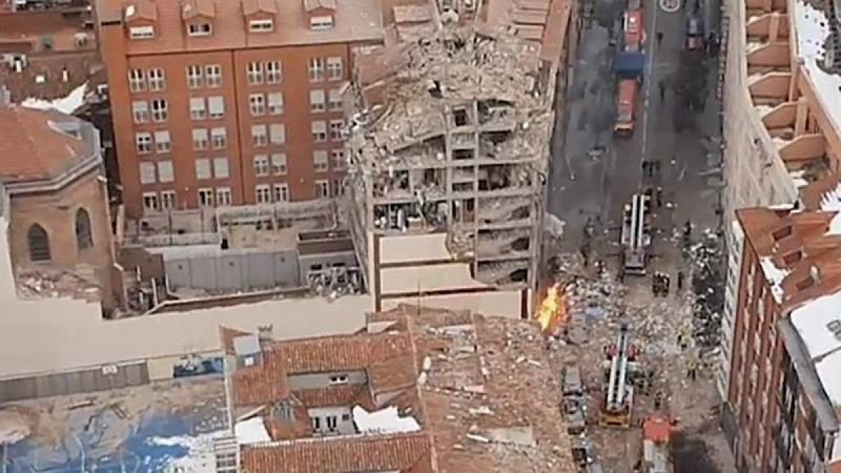 Vista aérea del estado en el que quedó el edificio y las casas colindantes. Los vecinos, en la calle tras la explosión. Los servicios de emergencias, en la zona. DAVID FERNÁNDEZ