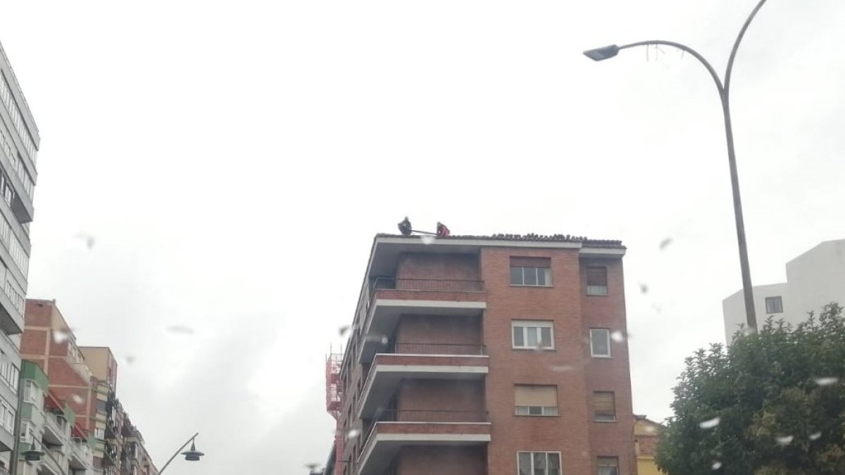 Operarios reparando el tejado de un edificio de León. PACHO RODRÍGUEZ