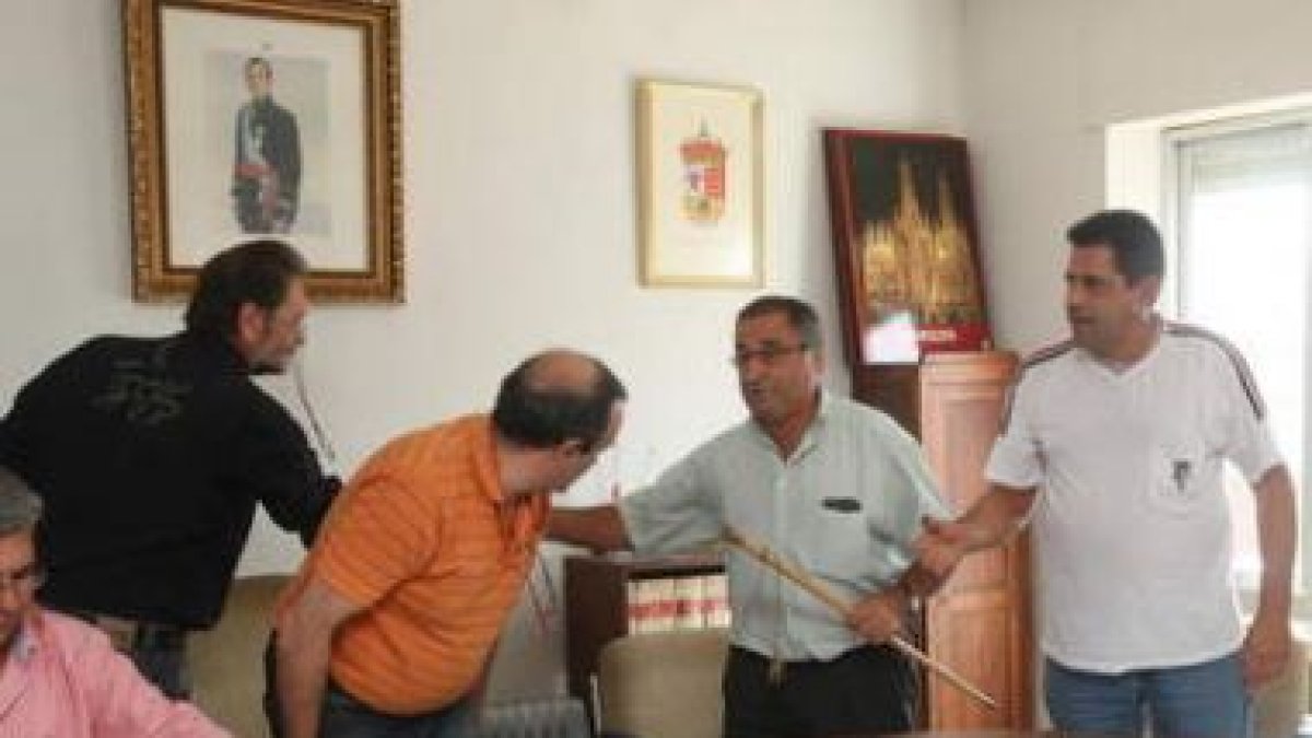 El nuevo alcalde recoge el bastón de mando del Ayuntamiento de Onzonilla tras ser elegido.
