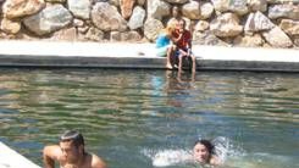 Varios jóvenes se refrescan en la piscina fluvial de Cebrones del Río