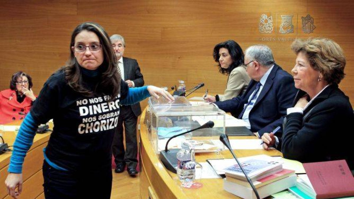 La diputada de Compromís, Mónica Oltra, luce la misma camiseta por la que fue expulsada esta mañana del pleno de Les Corts, durante la votación para elegir a los miembros de la mesa durante la constitución de la comisión de investigación sobre Emarsa, la