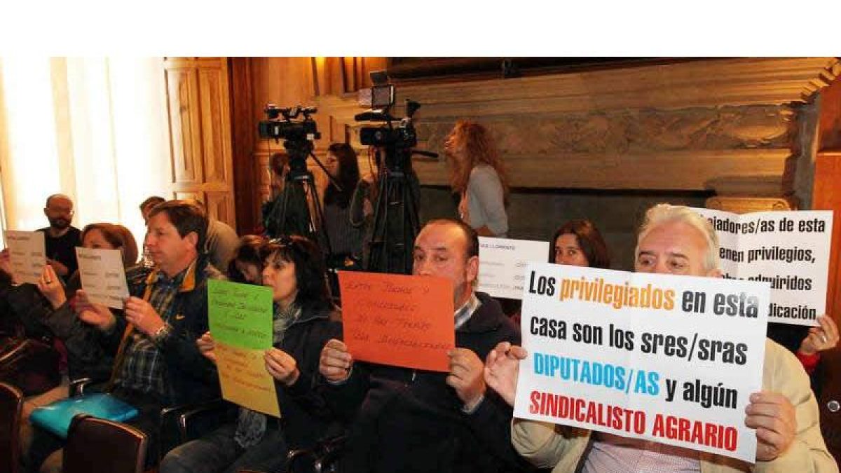 Pancartas de los trabajadores que protestaron ayer en el Pleno contra Matías Llorente, en la imagen a su salida del Pleno.
