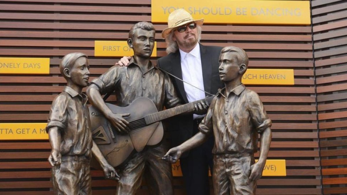 Barry Gibb posa junto a una estatua en honor de Barry Robin y Maurice Gibbs componentes del grupo Bee Gees en la inauguracion oficial del Paseo de lo Bee Gees en en Redcliffe, norte de Brisbane (Australia), en febrero del 2013.