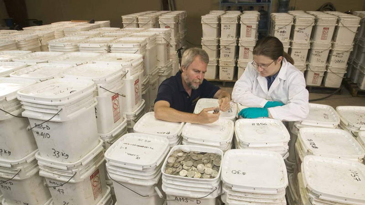 Greg Stemm, fundador de Odyssey, y un investigador, con las monedas del navío ‘Mercedes’.