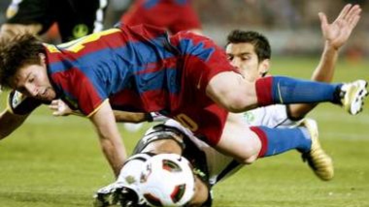 Messi pelea un balón con el defensa del Valencia Costa.