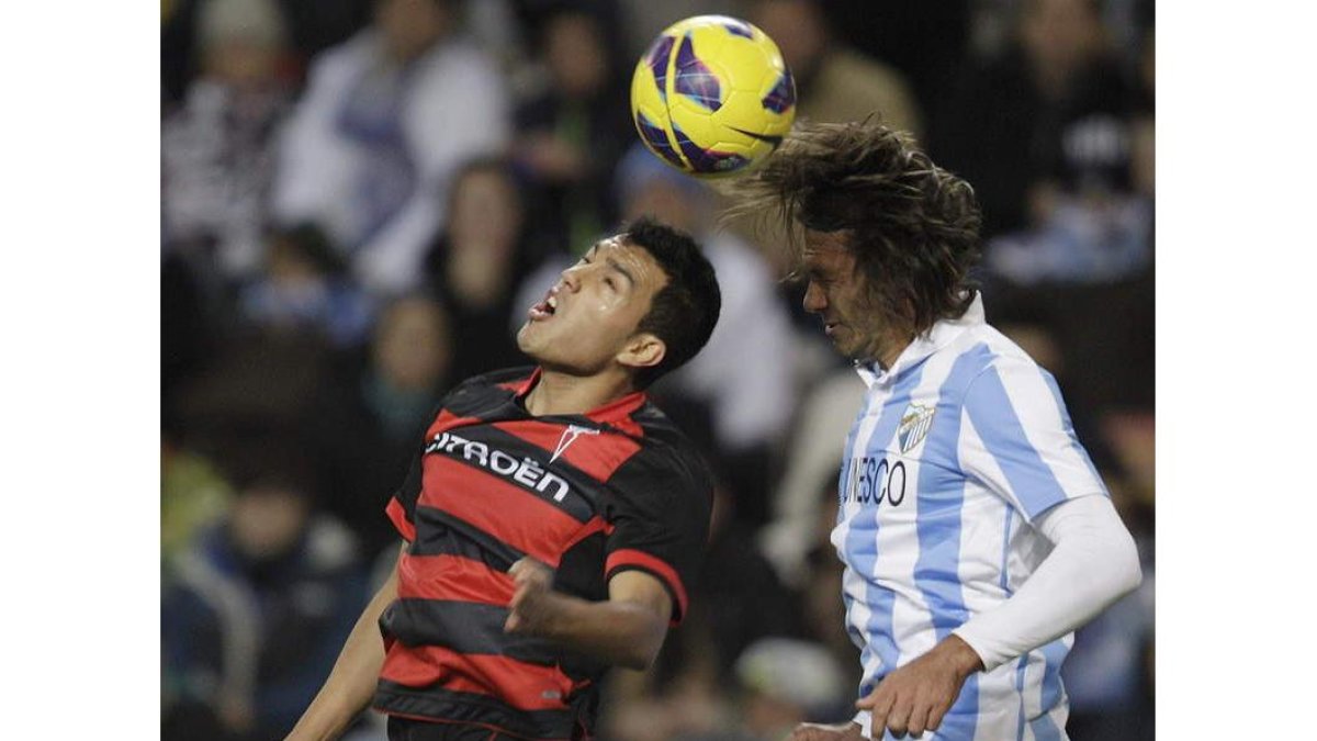 Cabral y Demichelis saltan al unísono para golpear el balón.