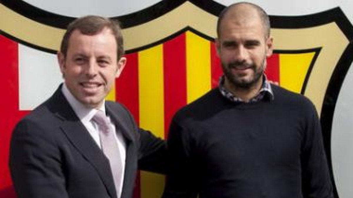 Rosell (i) estrecha la mano de Guardiola, tras renovar.
